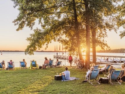 Entspannte Atmosphäre auf Liegestühlen am Berliner Müggelsee bei Sonnenuntergang
