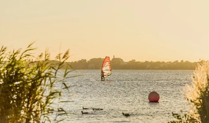 Surfer auf dem Großen Müggelsee in Berlin, ein beliebtes Ausflugsziel
